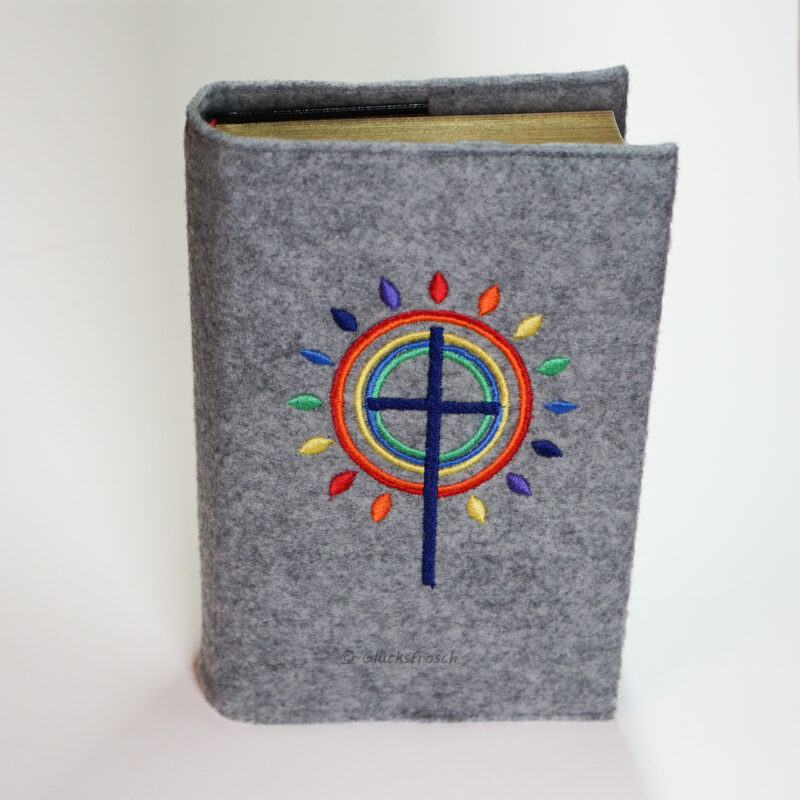 Gotteslobhülle, Filz, grau, mit grauem Kreuz und Strahlen, die wie eine Blume angeordnet, bunt wie ein Regenbogen